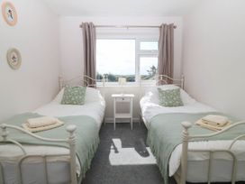 A bedroom with two beds and a window at Wilpol in Llanerchymedd