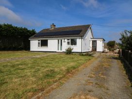 A house with solar panels and a driveway at Wilpol in Llanerchymedd