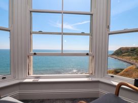 A view of the ocean and hills from a window in a living room at The Gulls Rest