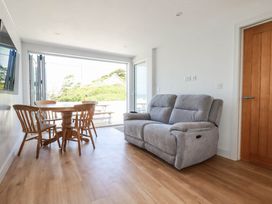 A living room with a sofa and dining table at 9 Tides Reach Wadebridge