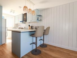 A kitchen with a counter and bar stools at 9 Tides Reach Wadebridge