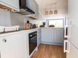 A kitchen with cabinets and appliances at 9 Tides Reach Wadebridge
