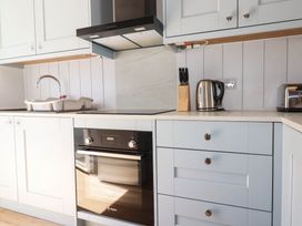 A kitchen with sink, kettle, toaster, and oven at 9 Tides Reach Wadebridge