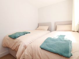 A bedroom with two single beds and blankets at 9 Tides Reach Wadebridge
