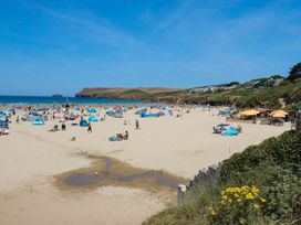 A beach scene with people, tents, and umbrellas at 9 Tides Reach Wadebridge