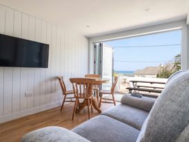 A living room with a television and dining area at 9 Tides Reach Wadebridge