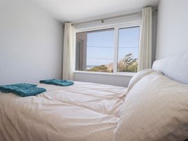 A bedroom with a bed and window at 9 Tides Reach Wadebridge