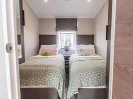 A bedroom with two beds and a window at Lakewood Plot 3 in St. Osyth
