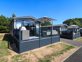 An outdoor area with a holiday home and deck at Lakewood Plot 5 St. Osyth