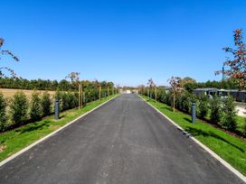 A road lined with trees and bushes at Lakewood Plot 5 in St. Osyth