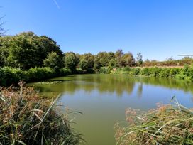 A pond surrounded by trees and greenery at Lakewood Plot 5 in St. Osyth