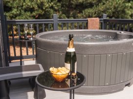 An outdoor area with a hot tub, champagne, and snacks at Lakewood Plot 5 St. Osyth