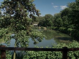 A pond surrounded by trees and grass at Lakewood Plot 5 St. Osyth