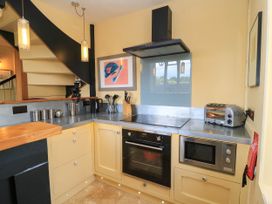A kitchen with a stove and cabinets at The Sunday School Room in Sherborne