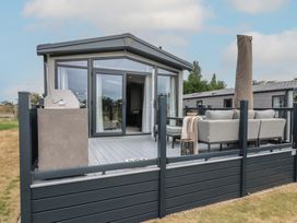 An outdoor area with a sofa and barbecue at Lodge 2 St. Osyth