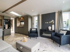 A living room with kitchen units and seating at Lodge 2 St. Osyth