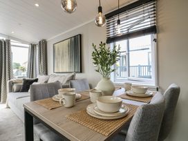 A dining room with a table set for dinner at Lodge 2 St. Osyth
