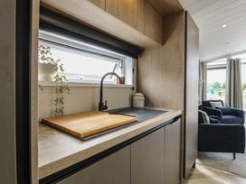 A kitchen with a sink and cutting board at Lodge 2 St. Osyth