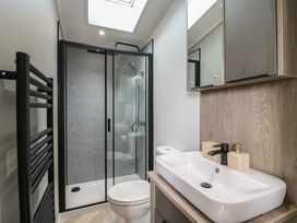 A bathroom with a shower, toilet, and sink at Lodge 2 St. Osyth