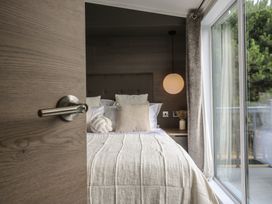 A bedroom with a bed and a door opening at Lodge 2 St. Osyth