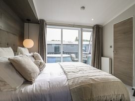 A bedroom with a bed and a window at Lodge 2 St. Osyth