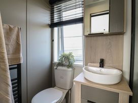 A bathroom with a sink and toilet at Lodge 2 St. Osyth