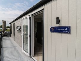 A deck area with a door and sign at Lakewood in St. Osyth
