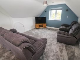 A living room with a sofa and television at 6 Coswinsawsin Lane near Camborne