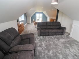 A living room with a sofa and a dining table at 6 Coswinsawsin Lane near Camborne