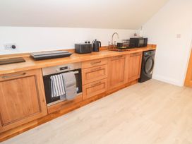 A kitchen with wooden cabinets and appliances at 6 Coswinsawsin Lane near Camborne