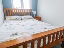 A bedroom with a bed and nightstand at 6 Coswinsawsin Lane near Camborne