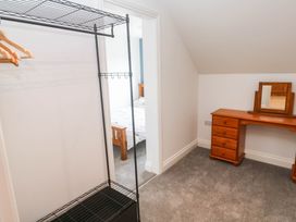 A bedroom with a clothes rack and a vanity table at 6 Coswinsawsin Lane near Camborne