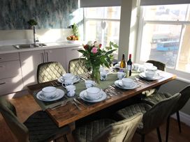 A dining room with a table set for a meal at Cornerhouse Apartment 1, Llandudno