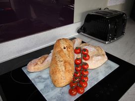 A kitchen countertop with bread and tomatoes at Cornerhouse Apartment 1, Llandudno