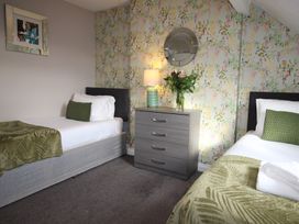 A bedroom with two beds and a dresser at Cornerhouse Apartment 1 in Llandudno