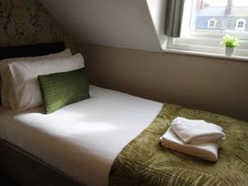 A bedroom with a bed and towels on it at Cornerhouse Apartment 1 in Llandudno