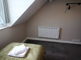 A bedroom with a bed and towels on it at Cornerhouse Apartment 1 in Llandudno