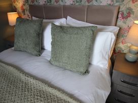 A bed with pillows and a bedside lamp at Cornerhouse Apartment 1 Llandudno