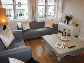 A living room with sofas, a coffee table, and a lamp at Cornerhouse Apartment 3 in Llandudno