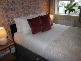 A bedroom with a bed and pillows at Cornerhouse Apartment 3 Llandudno