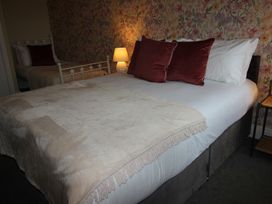 A bedroom with a bed and a bedside lamp at Cornerhouse Apartment 3 Llandudno