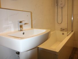 A bathroom with a washbasin and bathtub at Cornerhouse Apartment 3 in Llandudno