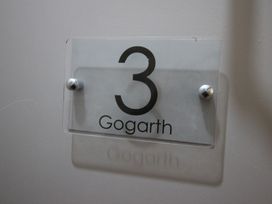 A nameplate displaying the number 3 and the name Gogarth at Cornerhouse Apartment 3 Llandudno
