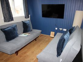 A living room with sofas and a television at Cornerhouse Apartment 4 Llandudno