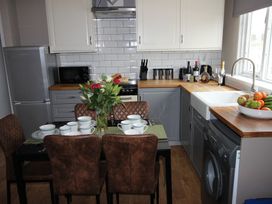 A kitchen with a dining table set for four at Cornerhouse Apartment 4 in Llandudno