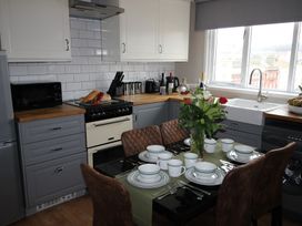 A kitchen with dining table and chairs at Cornerhouse Apartment 4 in Llandudno