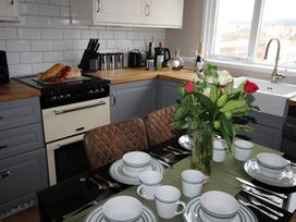 A kitchen with a dining table set and an oven at Cornerhouse Apartment 4 Llandudno