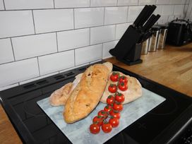 Bread and cherry tomatoes on a marble platter in a kitchen