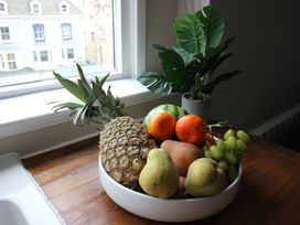 A bowl of fruits on a wooden table at Cornerhouse Apartment 4 in Llandudno
