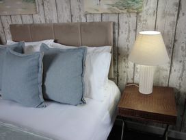 A bedroom with a bed and bedside lamp at Cornerhouse Apartment 4 Llandudno